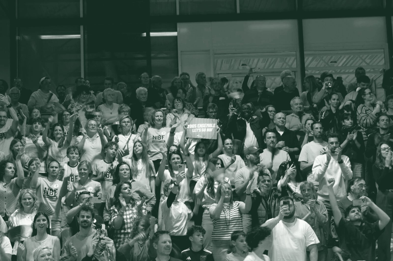 Tribune de supporters agitant des clappers en carton lors d'un match