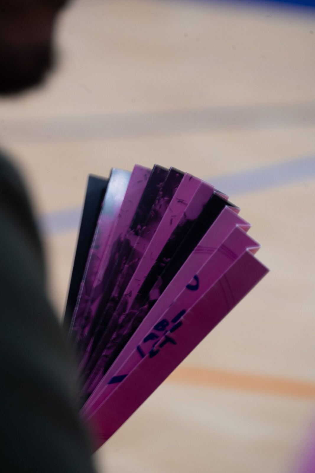 Éventail rose tenu par un supporter au bord du terrain